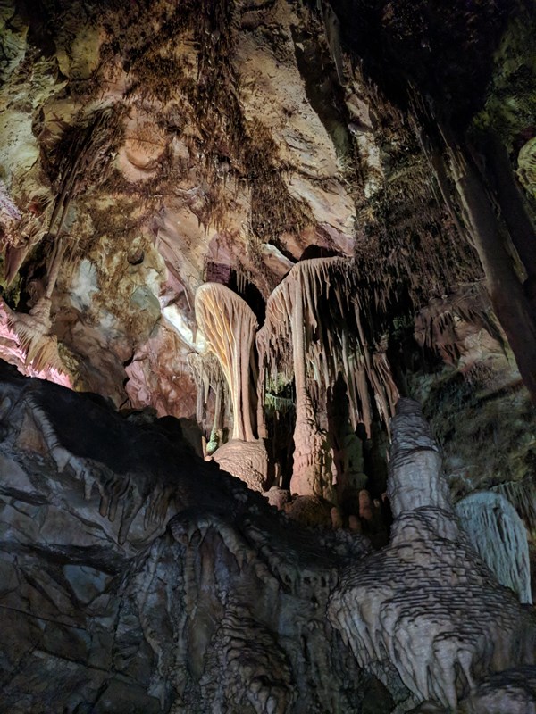 Stalactites and stalagmites in a cave formation with colored lighting